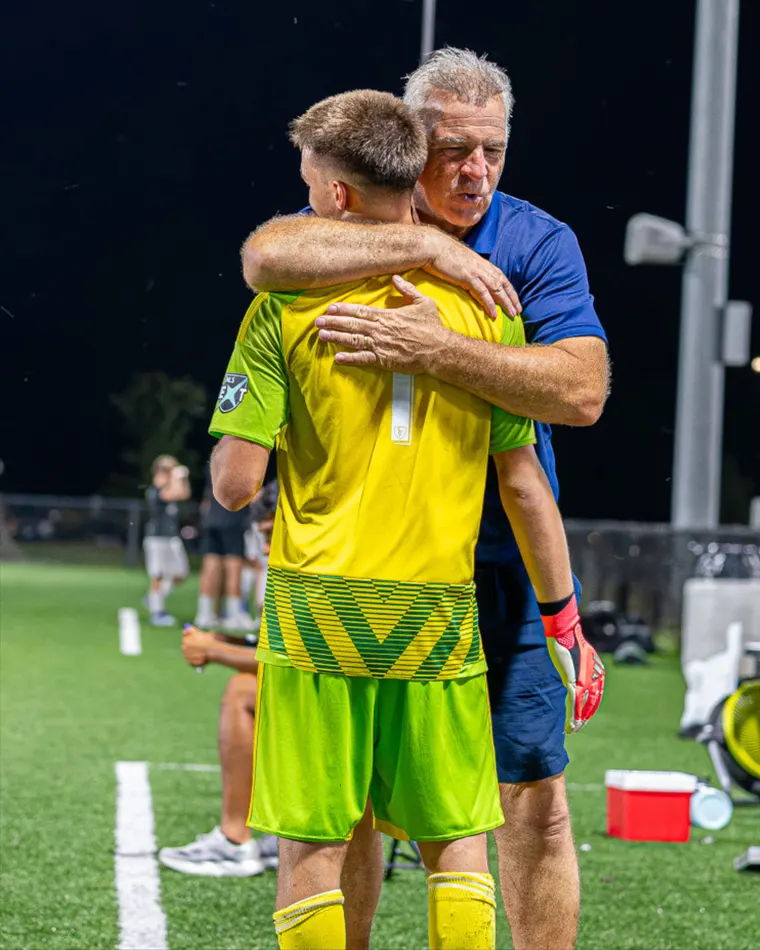 An SBV coach hugs his goalkeeper after a game